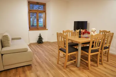 a living room with a table and chairs and a couch at Metropolitana's Zois Apartments in Bohinj