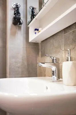 a white sink in a bathroom with a mirror at Metropolitana's Zois Apartments in Bohinj