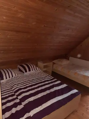 a bedroom with a bed in a wooden room at Pocitniska hisa na Pohorju in Pohorje