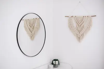 a mirror hanging on a white wall next to a shelf at Hygge House Bled in Bled