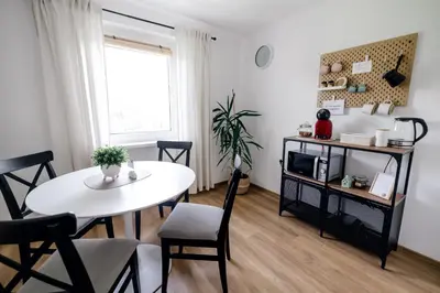 a living room with a white table and a tv at Hygge House Bled in Bled