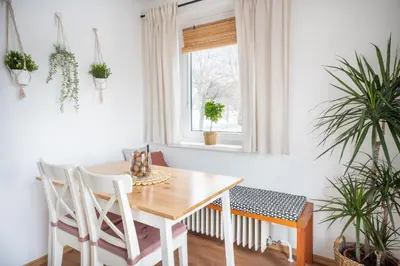 a dining room with a table and chairs and plants at Hygge House Bled in Bled