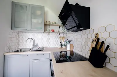 a kitchen with white cabinets and a sink at Hygge House Bled in Bled