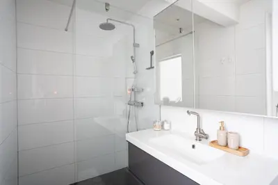 a white bathroom with a sink and a shower at Hygge House Bled in Bled