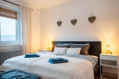 a bedroom with a bed with two blue towels on it at Hygge House Bled in Bled