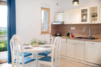 a kitchen with a table and chairs and a sink at Villa Azul in Kojsko