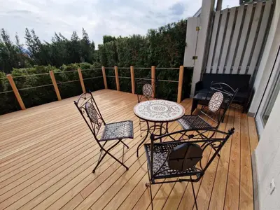a patio with four chairs and a table on a deck at Platinum Bled in Bled