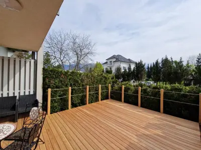 a wooden deck with two chairs on a house at Platinum Bled in Bled