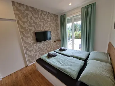 a bedroom with a bed and a tv on a wall at Platinum Bled in Bled