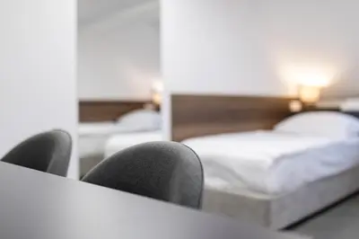 a hotel room with two beds and two chairs at Garni Hotel Cirman in Ljubljana