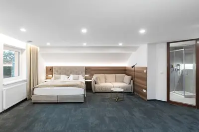 a hotel room with a bed and a couch at Garni Hotel Cirman in Ljubljana