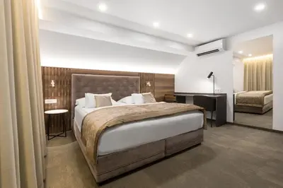 a bedroom with a large bed and a room with a bed sqor at Garni Hotel Cirman in Ljubljana