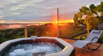 a hot tub on a deck with a chair and the sunset at Holiday home in Mirna Kranjska Krain 42906 in Mirna