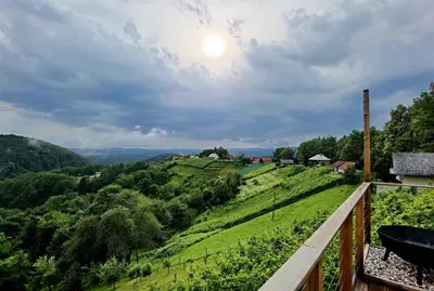 a view of a green hill with the sun in the sky at Holiday home in Mirna Kranjska Krain 42906 in Mirna