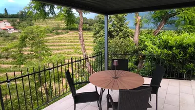 a table and chairs on a balcony with a view at Apartma Fojana in Dobrovo