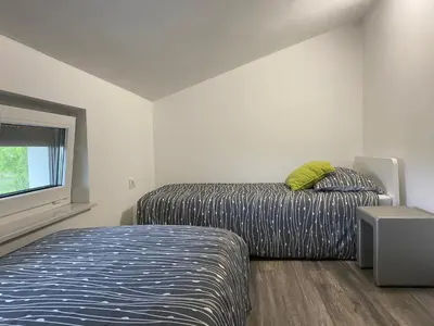 a bedroom with a bed and a window at Apartma Fojana in Dobrovo