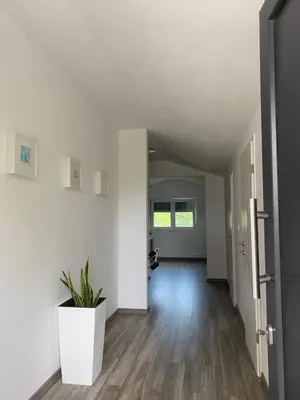 an empty hallway with white walls and a potted plant at Apartma Fojana in Dobrovo