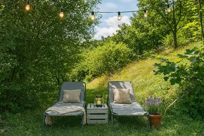 two chairs in the grass with a table and lights at Spacious nest between Maribor and Celje NiceHead in Loče pri Poljčanah