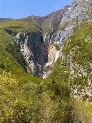 a waterfall in the middle of a mountain at Apartma Bovec Center in Bovec
