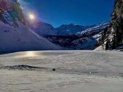 a view of a snow covered mountain and a lake at Apartma Bovec Center in Bovec