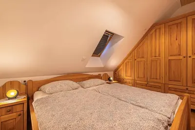 a bedroom with a bed with wooden cabinets and a window at Holiday home in Otocec Kranjska Krain 42907 in Otočec