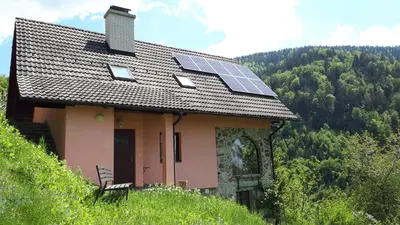 a house with solar panels on top of a hill at Country House & Spa in Mislinja