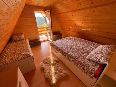 a attic bedroom with two beds and a window at Mountain View Cottage in Kamnik