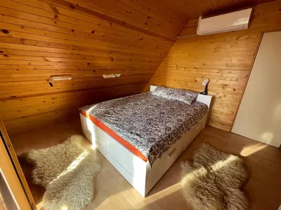 a bedroom with a bed in a wooden room at Mountain View Cottage in Kamnik