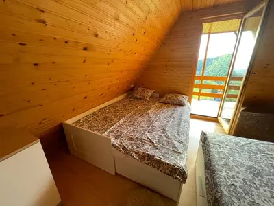 a bedroom with a bed in a wooden wall at Mountain View Cottage in Kamnik
