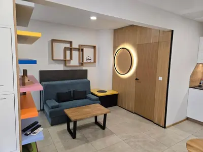 a living room with a couch and a table and a door at Apartment ARSO in Velenje