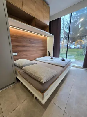 a large bed with a large wooden headboard in a room at Apartment ARSO in Velenje