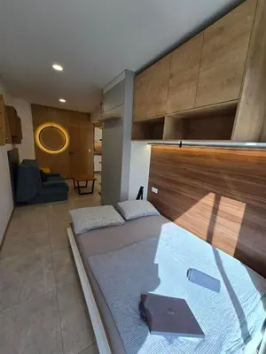 a bedroom with a large bed with a wooden headboard at Apartment ARSO in Velenje