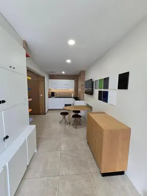 a living room with a table and a kitchen at Apartment ARSO in Velenje