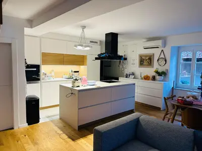 a kitchen with white cabinets and a couch in a room at Top view residence in central Ljubljana in Ljubljana