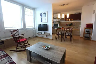 a living room with a table and chairs and a kitchen at Thomas apartment 028 in Ljubljana