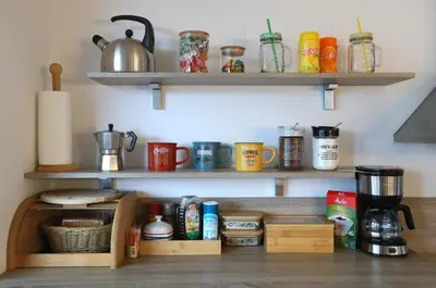 a kitchen with wooden shelves with cups and mugs at Thomas apartment 028 in Ljubljana