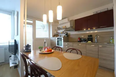 a kitchen with a wooden table with chairs and a dining room at Thomas apartment 028 in Ljubljana
