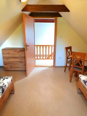 a room with two beds and a door with a balcony at Bohinj Star Apartments in Bohinj