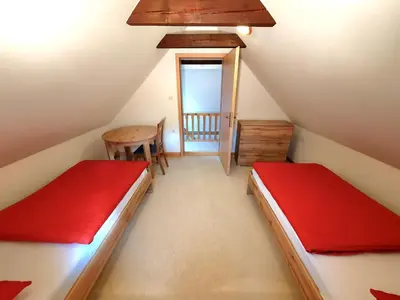 a attic room with two beds and a table at Bohinj Star Apartments in Bohinj