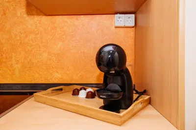 a coffee maker sitting on a wooden cutting board at Central View Point Apartment in Ljubljana