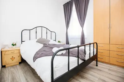 a bedroom with a bed and a dresser and a window at Central View Point Apartment in Ljubljana