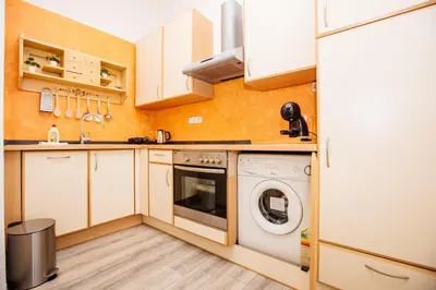 a small kitchen with a washer and dryer at Central View Point Apartment in Ljubljana