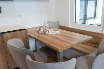 a wooden table in a kitchen with chairs at Hiša Rodica in Bohinj