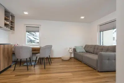 a living room with a couch and a table and chairs at Hiša Rodica in Bohinj