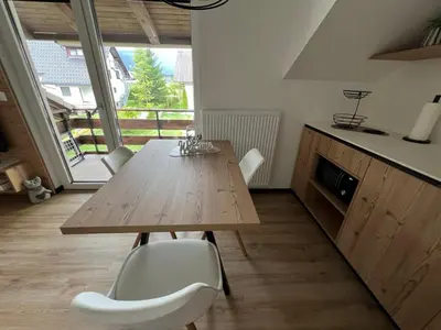 a dining room with a wooden table and chairs at Hiša Rodica in Bohinj
