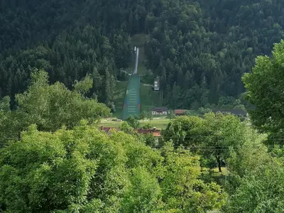 a park with a monument in the middle of trees at Lahova hiša in Ljubno