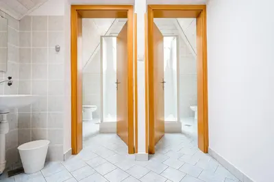 a bathroom with two toilets and a sink at Hostel Kronotop in Triglav National Park in Log pod Mangartom