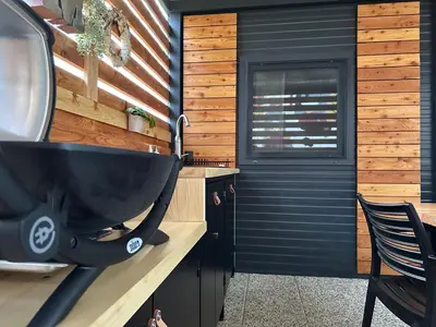 a bathroom with a black sink and a wooden wall at MAGNOLIA HOUSE by the RIVER in Metlika