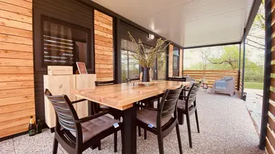 a dining room with a wooden table and chairs at MAGNOLIA HOUSE by the RIVER in Metlika