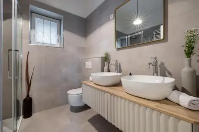 a bathroom with two sinks and a toilet and a mirror at City Central in Ljubljana